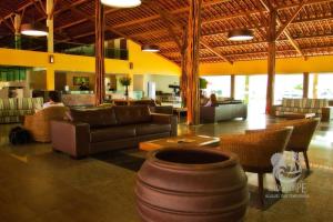 a lobby with a couch and chairs and a table at Ground floor flat with two suites (up to 8 people) at Canarius Resort in Gravatá in Gravatá