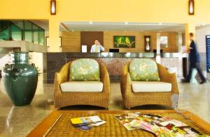 a lobby with two chairs and a counter with a vase at Ground floor flat with two suites (up to 8 people) at Canarius Resort in Gravatá in Gravatá +26 photos