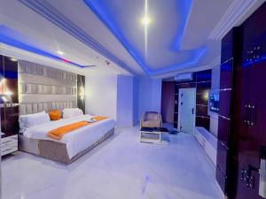 a bedroom with a king sized bed and a chair at Don Marble Hotel And Suites in Auchi