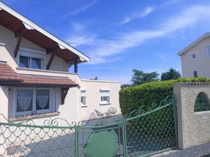 a green fence in front of a house at Studio chez Fred et Angela in Saint-Dizier