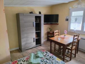 a dining room with a table and a tv at Studio chez Fred et Angela in Saint-Dizier