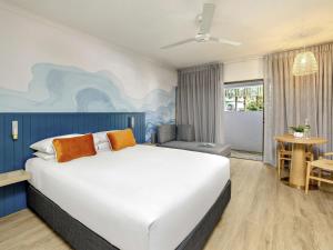 a bedroom with a large white bed in a room at Mercure Cairns in Cairns +72 photos