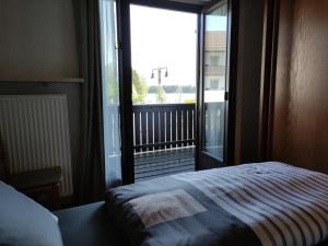 a bedroom with a bed and a large window at Apartment mit Seeblick - Hopfen am See in Füssen
