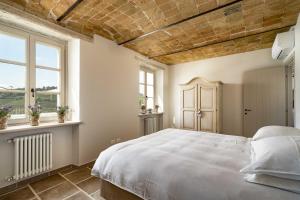 a bedroom with a white bed and two windows at Casa di Sofia in Calosso