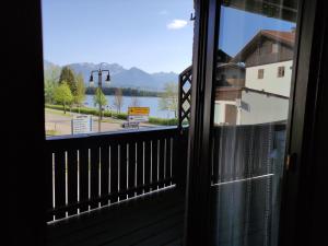 a view of a lake from a window at Apartment mit Seeblick - Hopfen am See in Füssen