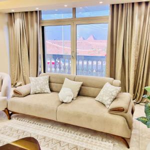 a living room with a couch and a large window at NOVA GATE Panorama Pyramids Suite in Giza