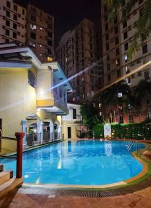 a large swimming pool in a city at night at LUCKY 7 Suites in Manila