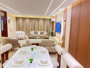 a living room with a couch and a table and chairs at NOVA GATE Panorama Pyramids Suite in Giza