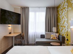 a hotel room with a bed and a couch at Mercure Hotel Stuttgart Gerlingen in Gerlingen