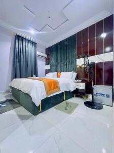 a bedroom with a large bed and a desk at Don Marble Hotel And Suites in Auchi