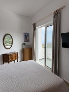 a bedroom with a bed and a large window at Art & Motion Union - Sunrise Room in Andros