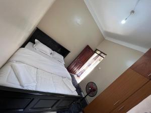 a bedroom with a bed with white sheets and a window at Regeneration in Jinja