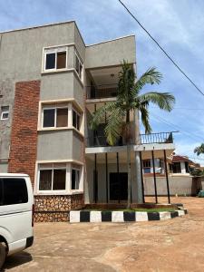 a building with a palm tree in front of it at Regeneration in Jinja