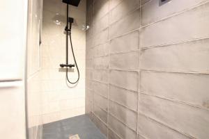 a shower in a bathroom with a tile wall at Axuri-alde in Sare +21 photos
