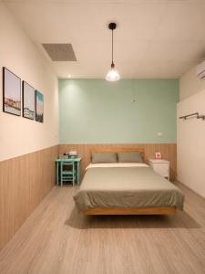 a bedroom with a large bed in a room at 巷弄內的老宅27 in Pingtung City +22 photos