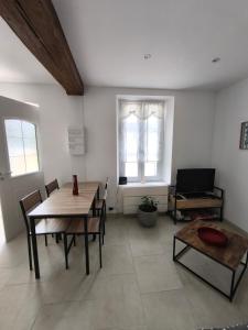 a living room with tables and chairs and a television at la longère du moulin in Noyers-sur-Cher
