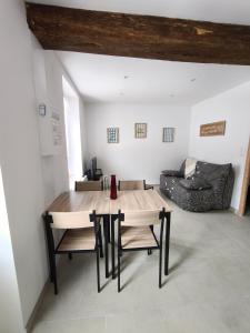 a living room with a table and chairs and a couch at la longère du moulin in Noyers-sur-Cher