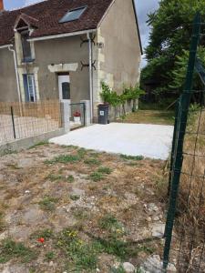 a fence in front of a house with a driveway at la longère du moulin in Noyers-sur-Cher