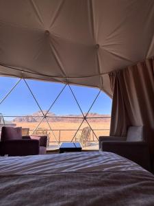 a bedroom with a view of the desert from a tent at وادي رم in Disah