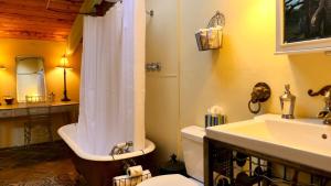 a bathroom with a tub and a toilet and a sink at Artist Chalet in Flagstaff +57 photos