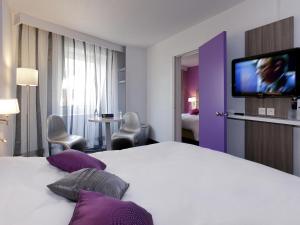 a hotel room with a bed and a flat screen tv at ibis Styles Grenoble Centre Gare in Grenoble +37 photos