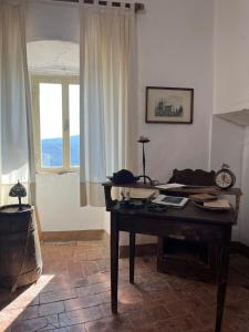 a living room with a table and a window at Castello di Mongiovino Vecchio "La Casa in Piazza" in Panicale +33 photos