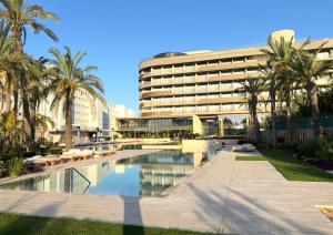 a hotel with a swimming pool in front of a building at The Nines in Ayia Napa