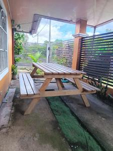 a wooden picnic table sitting on a patio at Frontera Stay Don Pinto in Canoa Abajo