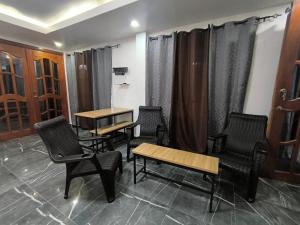 a waiting room with chairs and tables and curtains at Frontera Stay Don Pinto in Canoa Abajo +2 photos