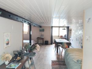 a living room with a bed and a table in it at Studio calme avec billard in Saint-Priest