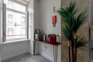 a room with a counter with a microwave and a window at Lisbon Poets Inn in Lisbon