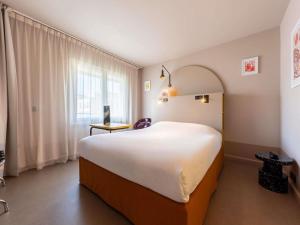 a large white bed in a room with a window at ibis Styles Marseille Centre Prado Place Castellane in Marseille +58 photos