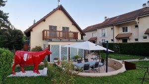 a red cow statue in front of a house at BnB "Les Coquelicots" in Mies