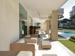 Vista esterna di una casa con sedie e piscina di Mercure Hotel Rimini Artis a Rimini