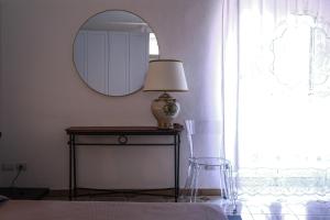 a bedroom with a table with a lamp and a mirror at Cupola Blu in Ragusa