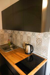 a kitchen counter with a sink and a tea kettle at WaterFall Hotel in Yerevan