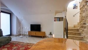 a living room with a table and a television at Cupola Blu in Ragusa