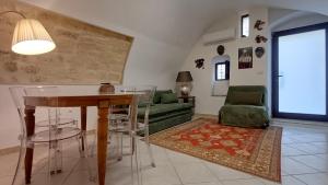 a living room with a table and a green couch at Cupola Blu in Ragusa