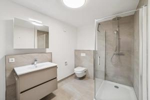 a bathroom with a toilet and a sink and a shower at Ferienwohnung Aquamarin Büsum in Westerdeichstrich