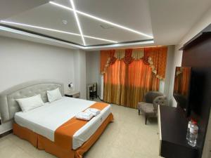 a bedroom with a bed and a flat screen tv at BRITNEY HOTEL Machala in Machala