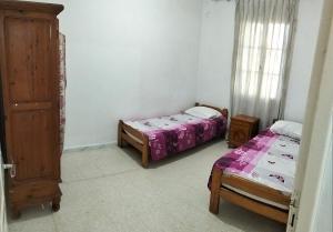 a bedroom with two beds and a dresser in it at Maison indépendante pieds dans l'eau in Sousse