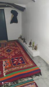 a room with a rug and a wall with figurines on it at Imlil agarssiwal in Aguersioual