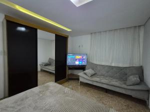 a living room with a couch and a flat screen tv at Flat Região Central 2 in Barbacena