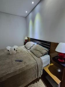 a bedroom with a bed with a teddy bear on it at Flat Região Central 2 in Barbacena