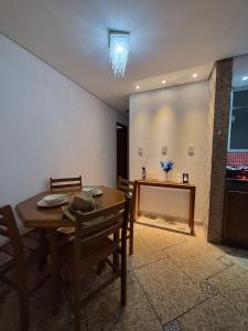 a dining room with a wooden table and chairs at Flat Região Central 2 in Barbacena
