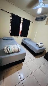 two beds in a room with black towels on the wall at Casa Aconchegante Uberlândia in Uberlândia