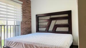 a bedroom with a bed and a brick wall at Torre 23 in Oaxaca City