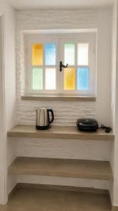 a tea kettle sitting on a shelf under a window at Est 1852 - Cozy in Andros