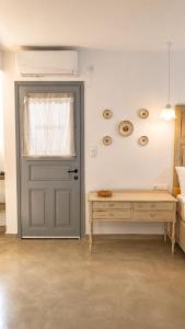 a room with a door and a bench and a table at Est 1852 - Cozy in Andros