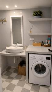 a bathroom with a washing machine and a sink at Est 1852 - Cozy in Andros